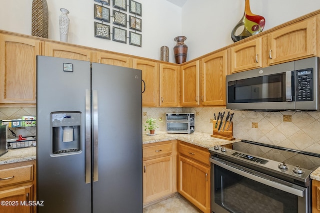 36425 S Golf Course Dr, Tucson, AZ 85739 - kitchen with light stone counters, decorative backsplash, appliances with stainless steel finishes, and a toaster