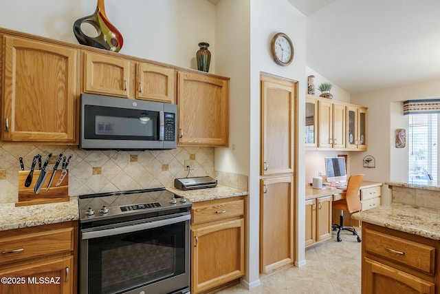 36425 S Golf Course Dr, Tucson, AZ 85739 - kitchen with light stone countertops, lofted ceiling, decorative backsplash, built in desk, and appliances with stainless steel finishes