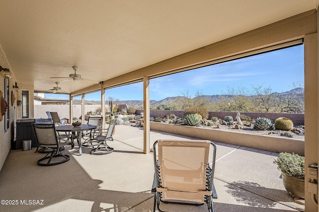 36425 S Golf Course Dr, Tucson, AZ 85739 - view of patio / terrace featuring a mountain view, outdoor dining area, ceiling fan, and fence