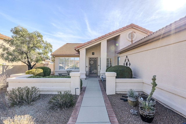 36425 S Golf Course Dr, Tucson, AZ 85739 - doorway to property with stucco siding, a tile roof, and fence