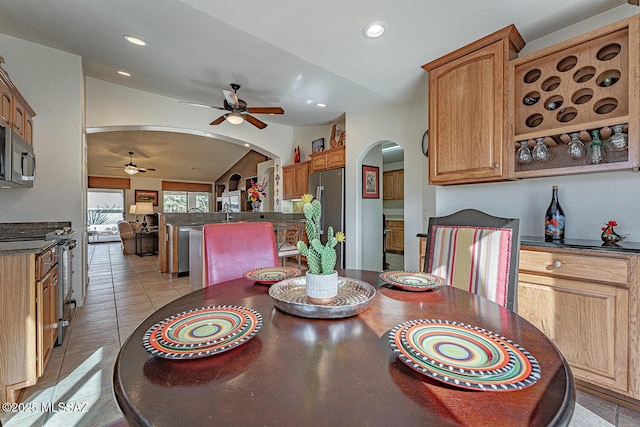 dining area with ceiling fan, lofted ceiling, and light tile patterned floors