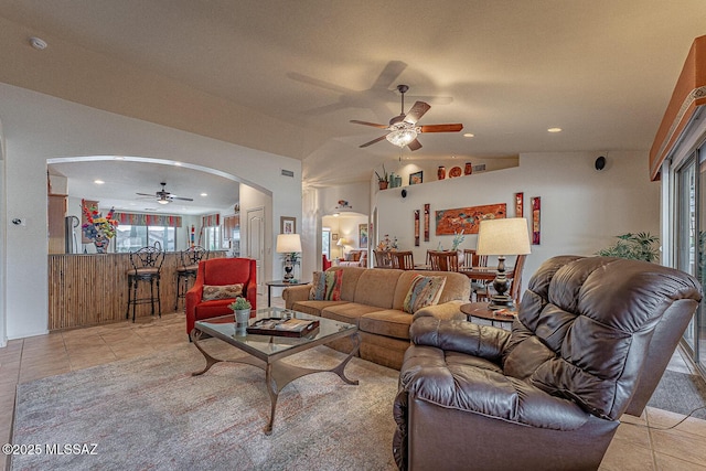 living room with lofted ceiling, light tile patterned floors, and ceiling fan