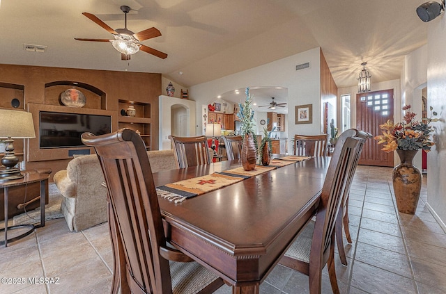 dining area featuring built in shelves, vaulted ceiling, and ceiling fan with notable chandelier