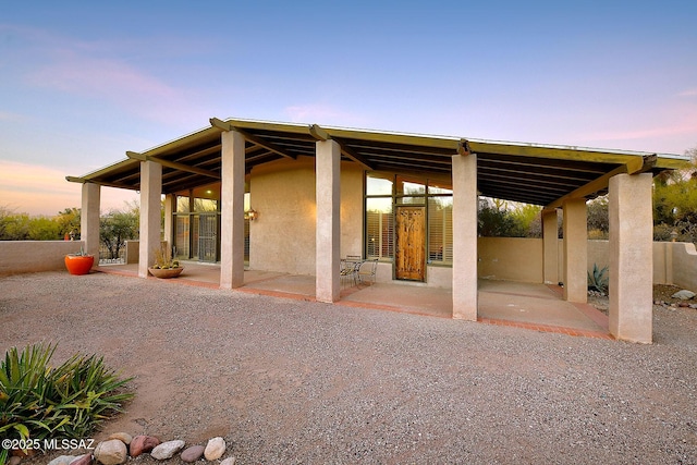 exterior space with stucco siding, a patio, and fence