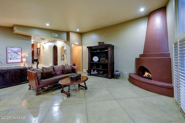 living room with arched walkways, baseboards, visible vents, and recessed lighting