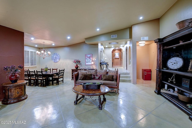 living area featuring lofted ceiling, visible vents, arched walkways, and recessed lighting