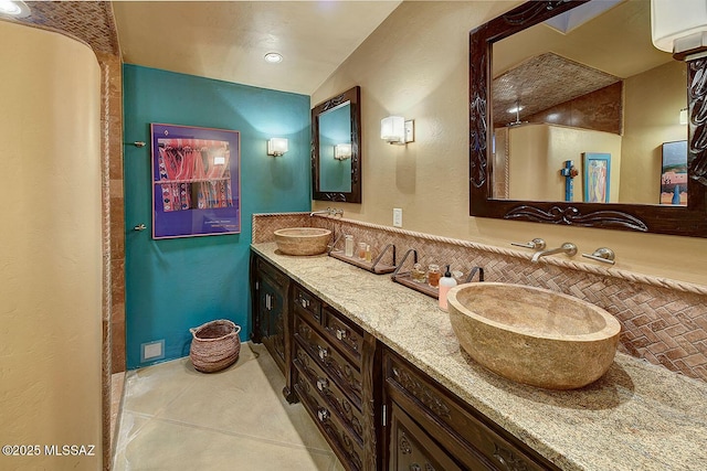 bathroom featuring tile patterned flooring, a wall unit AC, a sink, and double vanity