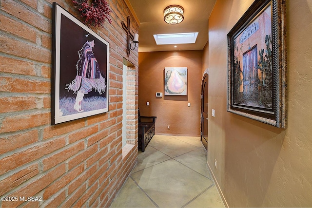 hall with a skylight and brick wall