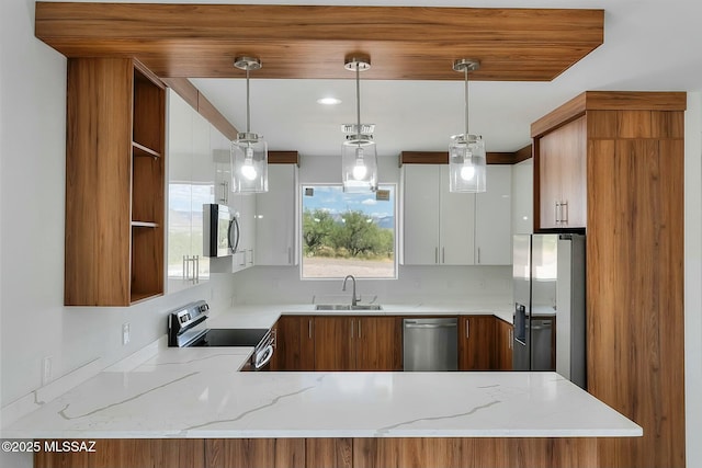 kitchen featuring appliances with stainless steel finishes, pendant lighting, white cabinets, light stone counters, and kitchen peninsula