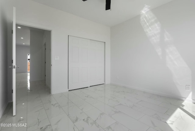 unfurnished bedroom with ceiling fan and a closet