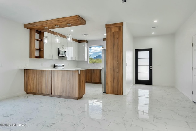 kitchen with sink, appliances with stainless steel finishes, white cabinetry, decorative light fixtures, and kitchen peninsula