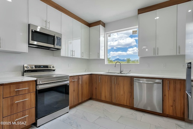 kitchen with stainless steel appliances, sink, and white cabinets