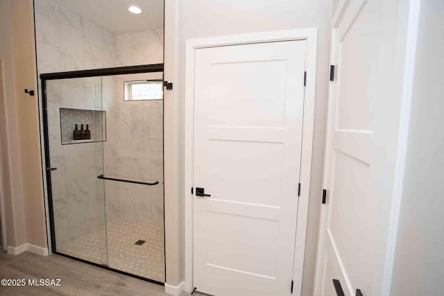 bathroom with a shower with door