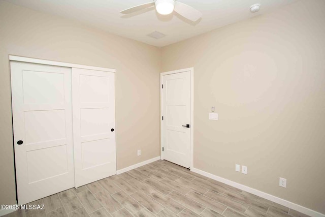 unfurnished bedroom featuring ceiling fan and a closet