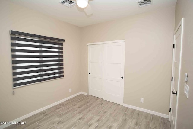 unfurnished bedroom with ceiling fan and a closet