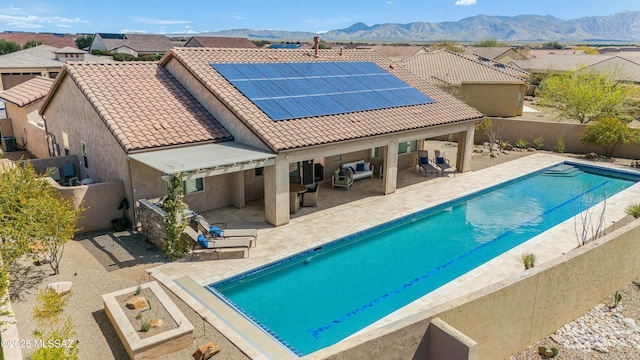 view of swimming pool with a mountain view and a patio area