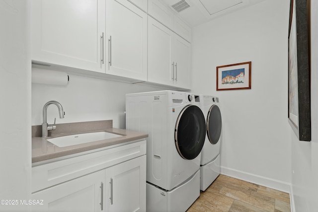 laundry area with cabinets, sink, and washing machine and clothes dryer