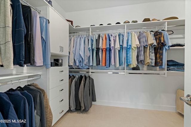 spacious closet featuring sink and light tile patterned floors