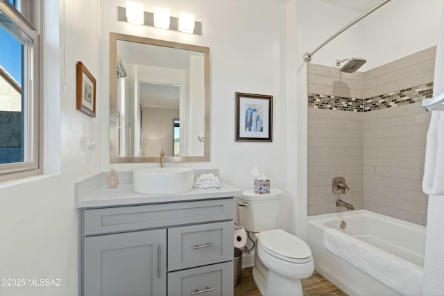 full bathroom with vanity, tiled shower / bath, and toilet