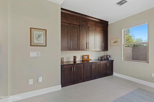 bar with crown molding and dark brown cabinetry