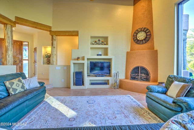 living room with built in shelves, a large fireplace, and light tile patterned flooring