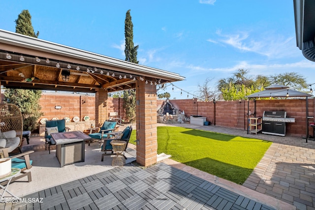 view of patio / terrace featuring a gazebo, an outdoor living space with a fire pit, and grilling area