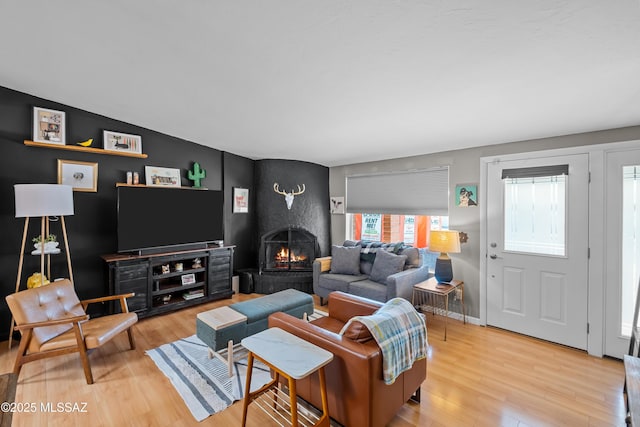 living room with wood-type flooring and a large fireplace