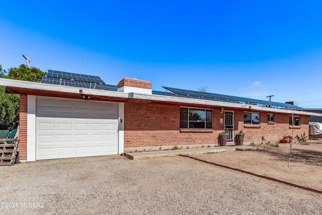 single story home featuring a garage and solar panels