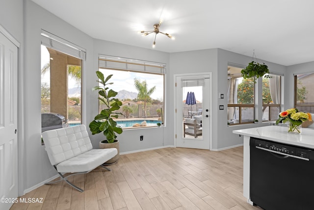 living area with an inviting chandelier and light wood-type flooring