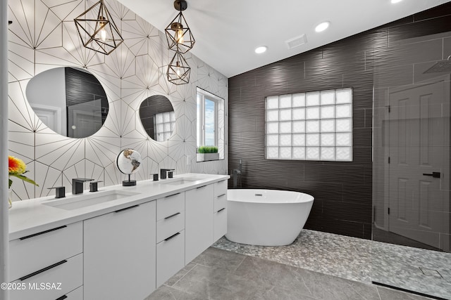 bathroom featuring tile walls, vanity, and a bathing tub