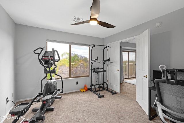 workout room with ceiling fan, light colored carpet, and a healthy amount of sunlight