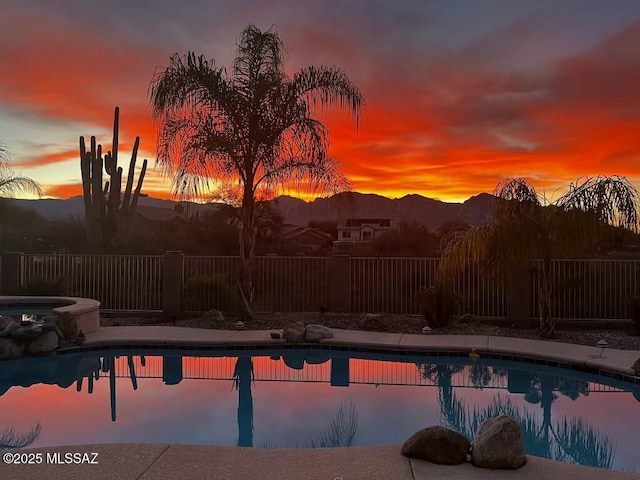 pool at dusk featuring a mountain view