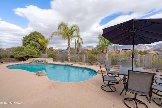 view of pool featuring a mountain view, a patio area, pool water feature, and an in ground hot tub