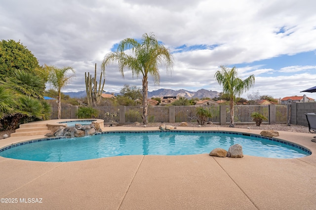 view of pool with a mountain view, a patio area, pool water feature, and an in ground hot tub