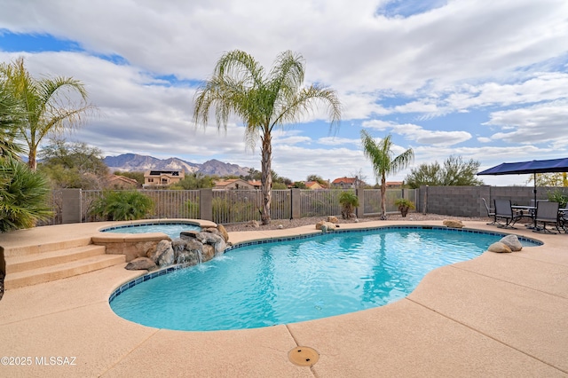 view of swimming pool featuring a mountain view, a patio area, pool water feature, and an in ground hot tub