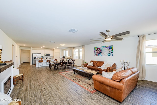 living room featuring hardwood / wood-style floors and ceiling fan