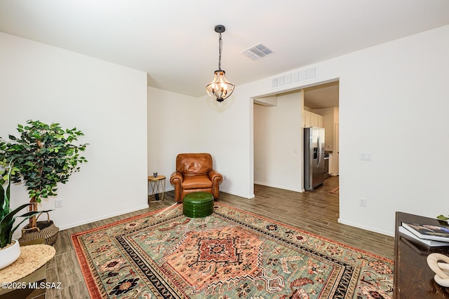 living area with an inviting chandelier and dark hardwood / wood-style floors