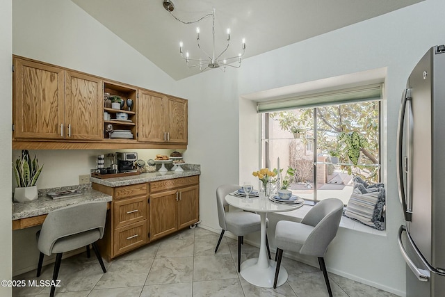 kitchen featuring open shelves, a chandelier, brown cabinetry, and freestanding refrigerator