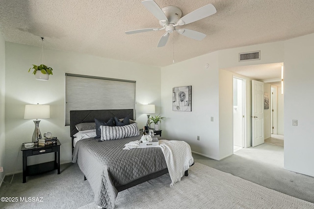 carpeted bedroom with baseboards, visible vents, a textured ceiling, and a ceiling fan