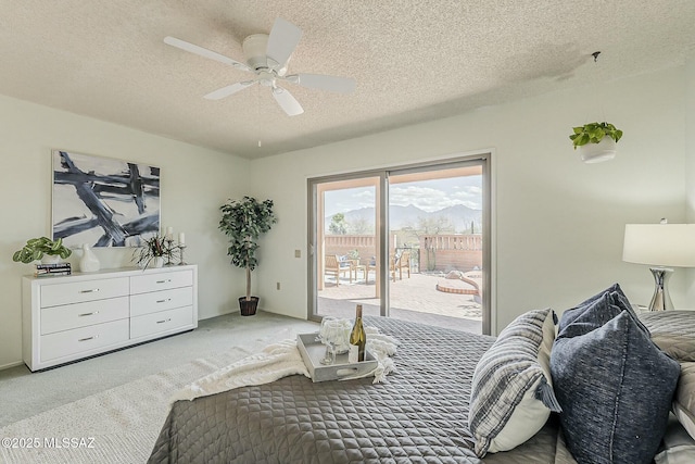 bedroom with access to exterior, carpet flooring, a textured ceiling, and a ceiling fan