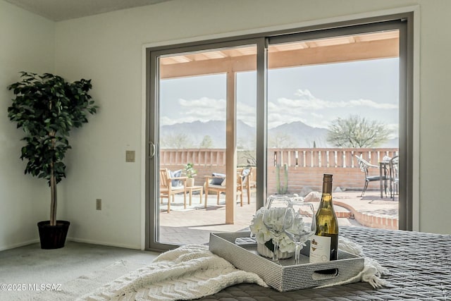 doorway featuring baseboards, a mountain view, and carpet floors