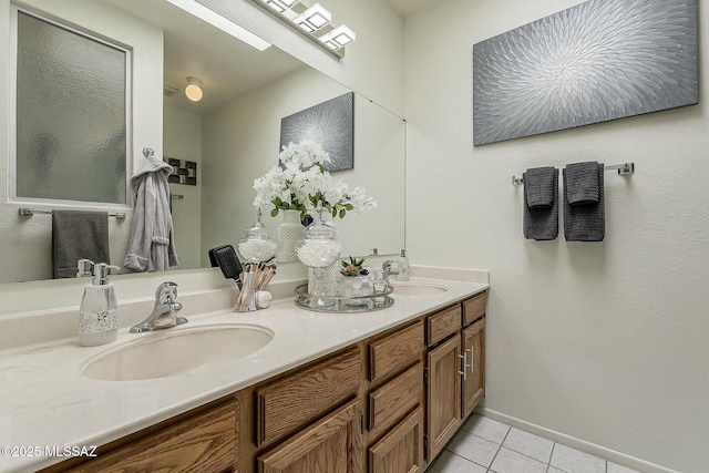 bathroom with tile patterned flooring, double vanity, baseboards, and a sink