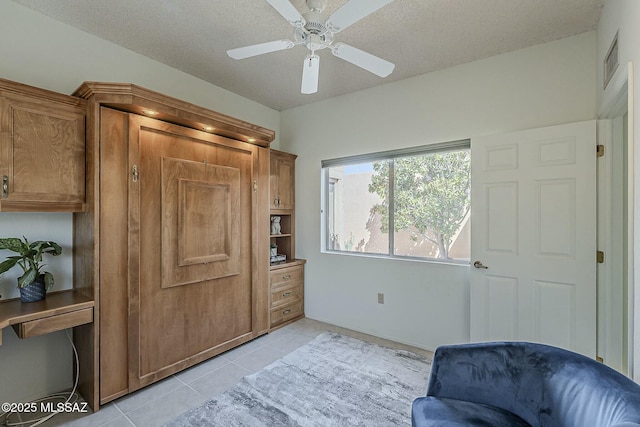 sitting room with light tile patterned floors, a textured ceiling, and a ceiling fan