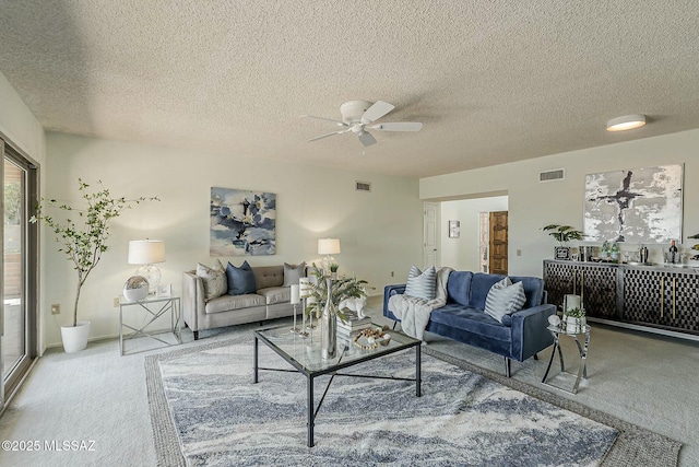 living area featuring visible vents, carpet floors, a textured ceiling, and ceiling fan