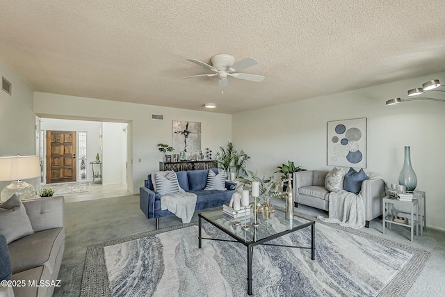 carpeted living room featuring visible vents, a textured ceiling, and a ceiling fan