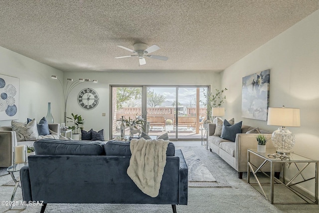 living area featuring a textured ceiling, ceiling fan, and carpet flooring