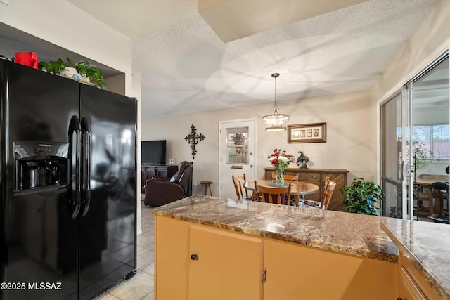 kitchen featuring pendant lighting, light tile patterned flooring, black refrigerator with ice dispenser, and a textured ceiling