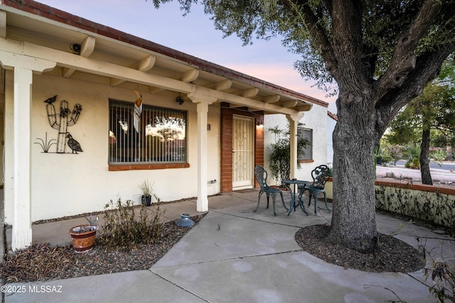 exterior entry at dusk with a patio area