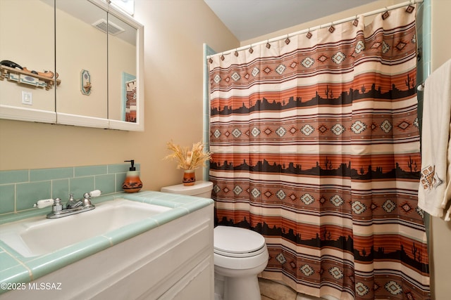 bathroom featuring vanity, toilet, and decorative backsplash