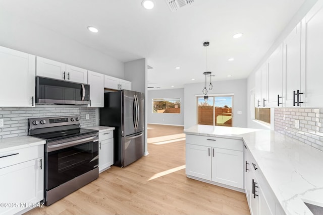 kitchen featuring light wood finished floors, visible vents, white cabinets, stainless steel appliances, and pendant lighting